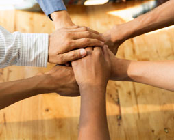 Hands stacked on each other, representing how West Chester employment lawyers help employers avoid internal conflicts.